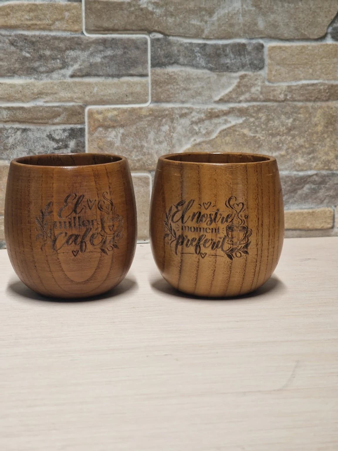 Dos tazas de madera para café grabadas con frases distintas